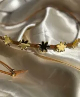 Gargantilla de cuero marrón con flores de acrílico rosado y tiras de cuero para atar.