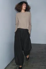 Pantalón de tiro medio confeccionado en mezcla de algodón, con diseño de corte recto y holgado. Presenta cintura con trabillas, cierre frontal con cremallera y botón, y bolsillos laterales ocultos en las costuras.