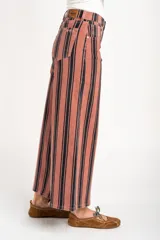 Jean wide leg de tiro alto con diseño de rayas verticales oscuras sobre base rosada, con bolsillos laterales y traseros y presillas para cinto.