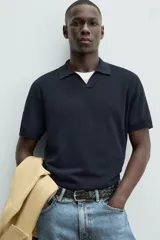 Jersey de punto color verde oliva, de calce relajado (relaxed fit), con cuello solapa y abertura frontal en forma de V. Es de manga corta y presenta acabados en rib en puños y ruedo.