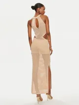 Vestido largo de tejido de punto color beige, con cuello halter y aberturas laterales. El tejido es calado con un patrón de pequeños rombos.