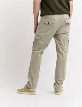 Pantalón de gabardina color marrón, corte slim fit, con bolsillos laterales tipo cargo.