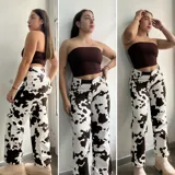 Pantalón de jean blanco con estampado de manchas de vaca en color marrón. Corte recto, tiro alto y cinturón de cuero marrón con hebilla plateada.