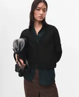 Cardigan de punto fino color negro, de corte recto, con escote en V, mangas largas y cierre frontal de botones.
