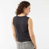 Musculosa negra de corte crop, con cuello redondo y diseño sin mangas. Presenta un estampado frontal con la inscripción "Guns N' Roses" en efecto desgastado, acompañado de pistolas y rosas rosadas.