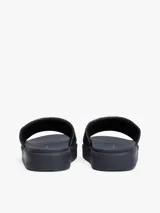 Ojotas de plataforma color azul marino con pala ancha acolchada con monograma TH en relieve y un pequeño logo metálico dorado en el centro.