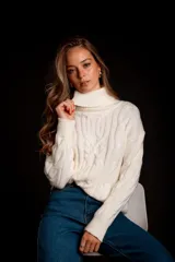 Suéter tejido de punto trenzado color salmón, con cuello alto y mangas largas. Corte ajustado al cuerpo.