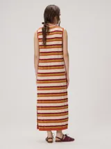 Vestido midi sin mangas de corte holgado, con diseño de rayas horizontales en tonos verde azulado, marrón y rosado. Presenta cuello redondo y aberturas laterales en el dobladillo.