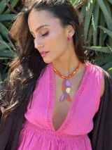 Collar con cuentas de vidrio color naranja y amarillo, con colgante de forma abstracta en color marrón, lila y amarillo. Cierre con cadena de acero quirúrgico y ganchito para regular el largo.