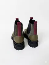 Botas tipo chelsea de cuero, combinando texturas en color bordó. Presentan paneles laterales elásticos en negro, suela track robusta y tiradores en la parte superior.