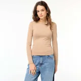 Remera color beige de corte cropped, con cuello redondo y mangas largas. Presenta un frunce lateral que genera un efecto arrugado.