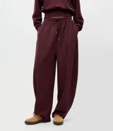Pantalón de corte barrel con piernas anchas y cintura cónica, confeccionado en tejido de modal con acabado liso. Presenta cintura elástica con lazo ajustable y diseño fluido.