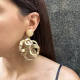 Aros colgantes dorados con cabezal circular y diseño de eslabones irregulares.