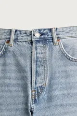 Jeans regular fit confeccionados en denim de algodón celeste con efecto lavado, de cinco bolsillos y cierre frontal con cremallera y botón.