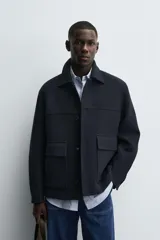 Chaquetón de corte regular fit, con cuello solapa, manga larga y cierre frontal con botones. Presenta dos bolsillos de plastrón con solapa en la parte frontal y un bolsillo interior.
