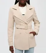 Saco negro de poliéster, de doble botonadura, con cuello estructurado, solapas amplias, bolsillos laterales y trabillas en los puños.