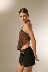 Top de cuello halter con diseño fruncido y caída holgada, confeccionado en tela con estampado de puntos.