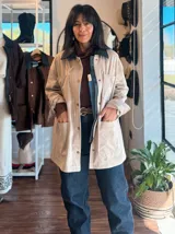 Campera de ecocuero color chocolate, con corte amplio y relajado. Presenta cuello camisero, cierre frontal con botones metálicos y bolsillos frontales de gran tamaño.