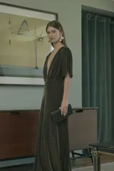 Vestido largo de lurex con acabado brillante en color negro y dorado, de escote en V profundo, mangas cortas amplias y cintura elástica.