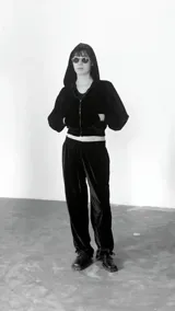 Campera negra de terciopelo con capucha doble, cierre frontal, dos bolsillos y frunce en puños y cintura.