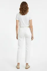 Pantalón jean blanco de corte recto y tiro medio, con bolsillos laterales y traseros, y terminación desmechada en los tobillos.