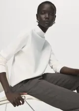 Jersey de punto fino con cuello perkins y manga larga, de diseño recto y corte clásico.