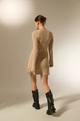 Vestido corto de punto acanalado, color negro, con cuello redondo a la base y mangas largas.