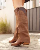 Bota alta de cuero y gamuza color marrón, con diseño 2 en 1 que incluye estribo desmontable, taco cuadrado y punta cuadrada.