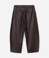 Pantalón de cuero sintético con corte barrel, de tiro alto y pierna ancha con estructura curva. Presenta bolsillos laterales tipo cuchillo y costuras decorativas con pespuntes visibles.