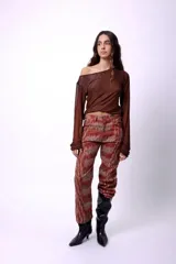 Top de manga larga con diseño de hombros descubiertos y estampado de letras repetidas en color rojo sobre fondo marrón.