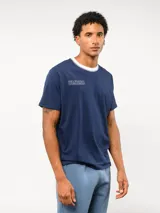 Remera de corte clásico color blanco, con cuello redondo en color rosado y logo de la marca bordado en el pecho en el mismo tono.