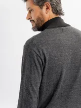 Buzo de punto color marrón oscuro con cuello alto y cierre frontal parcial de cuatro botones. Presenta una textura jaspeada y puños acanalados.
