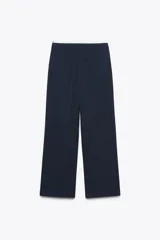 Pantalón de tiro alto color gris oscuro con finas rayas verticales blancas (pinstripe). Posee pernera recta y ancha, y doble cintura elástica con tejido combinado.