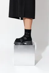 Botas cortas negras de cuero vegano con plataforma y múltiples hebillas.