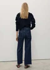 Jeans culotte de tiro alto color azul oscuro, confeccionados en tejido elástico de algodón estilo tejano vaquero. Presentan diseño de perneras anchas, trabillas para cinto, cierre de cremallera y botón, bolsillos traseros y bajo deshilachado.