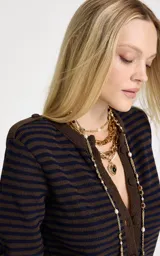 Cárdigan de punto con patrón de rayas horizontales en tonos marrón y azul marino. Presenta cuello redondo, mangas largas, cierre frontal con botones forrados y acabados acanalados en puños y ruedo.