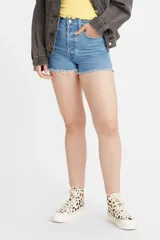 Short de jean de tiro alto con ruedo deshilachado y cierre frontal con botones, en un tono azul medio.