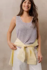 Chaleco tejido calado de color amarillo, con escote redondo, tirantes anchos y calce relajado. Cuenta con terminaciones en rib en el ruedo.