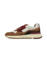 Sneaker deportivo de cueros combinados en tonos marrón, bordó, beige y detalles plateados texturados, con cordones y suela chunky de goma.