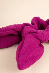 Gomita de pelo tipo scrunchie con moña color violeta.