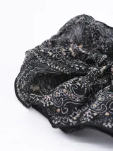 Coletero de tela estampada en tonos negros y beige.