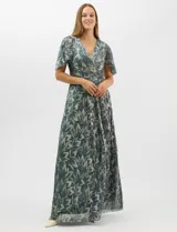 Vestido largo de fiesta con diseño cruzado, escote en V y drapeado lateral en la cintura. Presenta mangas cortas acampanadas y falda amplia con caída fluida. Confeccionado en tejido liviano con acabado plisado y estampado floral metalizado.