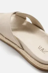Sandalia plana color beige con dos tiras anchas cruzadas en el empeine, plantilla anatómica y suela forrada en yute.