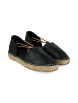 Alpargata estilo d'Orsay de cuero napa color negro con base de yute levemente elevada y tiras de ajuste elásticas en tono tostado.