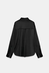Camisa de satén color blanco, de corte clásico con cuello solapa, manga larga con puños y cierre frontal con botones dorados.