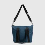 Bolso tipo tote color amarillo, de diseño acolchado con costuras horizontales. Cuenta con doble asa de mano y una correa larga ajustable y extraíble. Incluye un pequeño detalle de etiqueta lateral.
