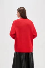 Saco de punto abierto, color rojo, con mangas largas holgadas y diseño de corte amplio.