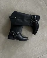Bota de cuero negra con caña alta y estribo desmontable.