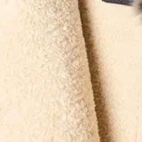 Campera estilo aviador con cuerpo de gamuza sintética color marrón y mangas de cuero sintético negro. Presenta cuello con solapas de piel sintética, interior forrado en corderito y cierre frontal con cremallera.