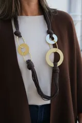 Collar largo de diseño artesanal compuesto por múltiples hilos de cordón color chocolate, con nudos decorativos y eslabones metálicos circulares y ovalados en tonos dorado y plateado.